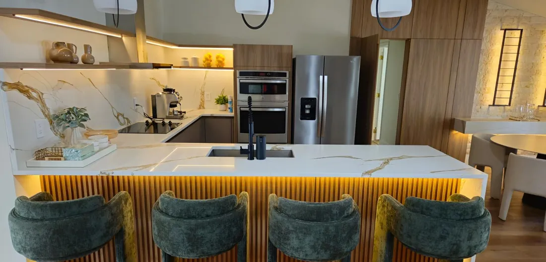 Kitchen with a calacatta look waterfall island and gold veining, fabricated and installed by Onyx