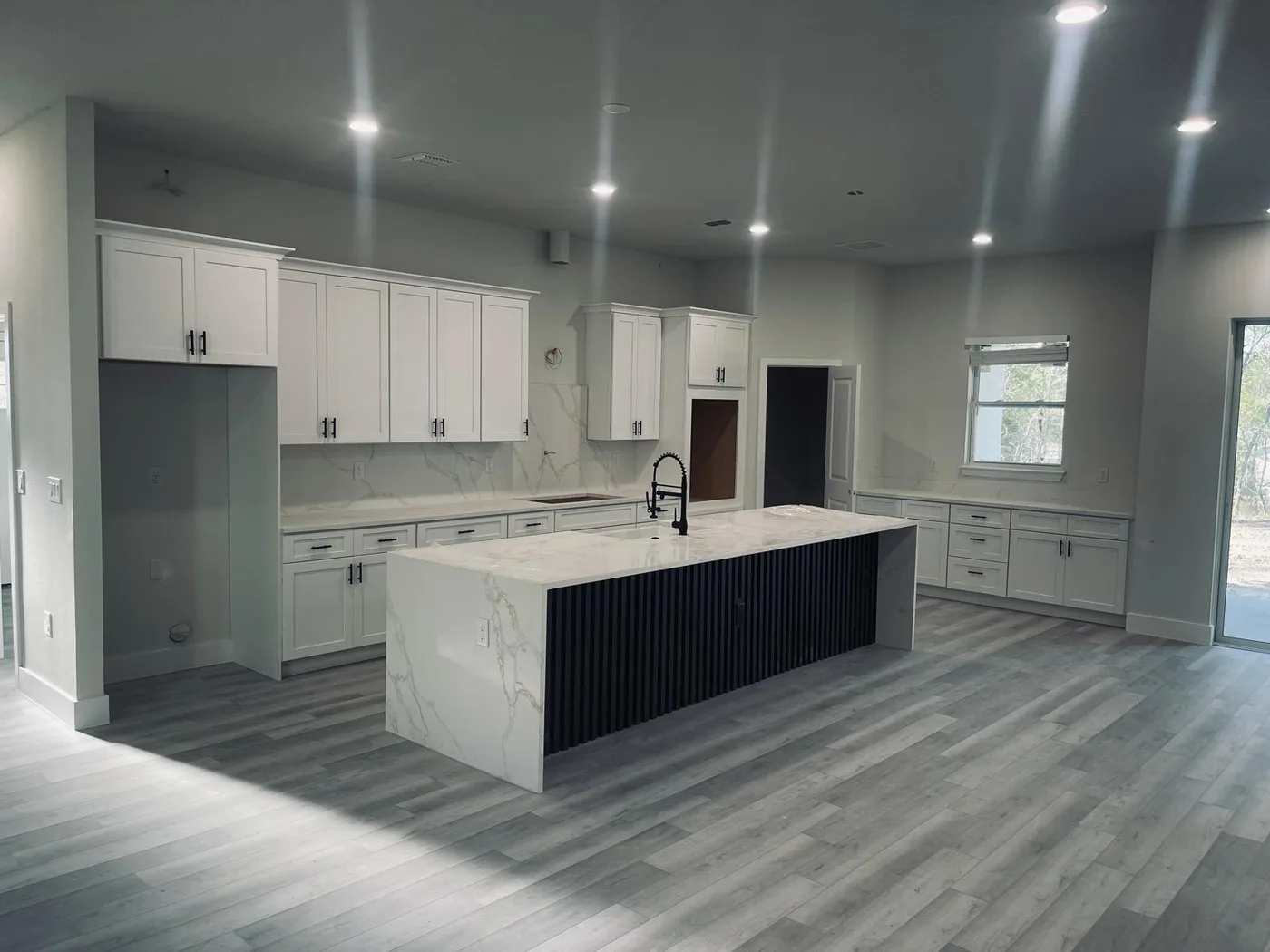 Remodeled kitchen with a white stone island and perimeter countertops